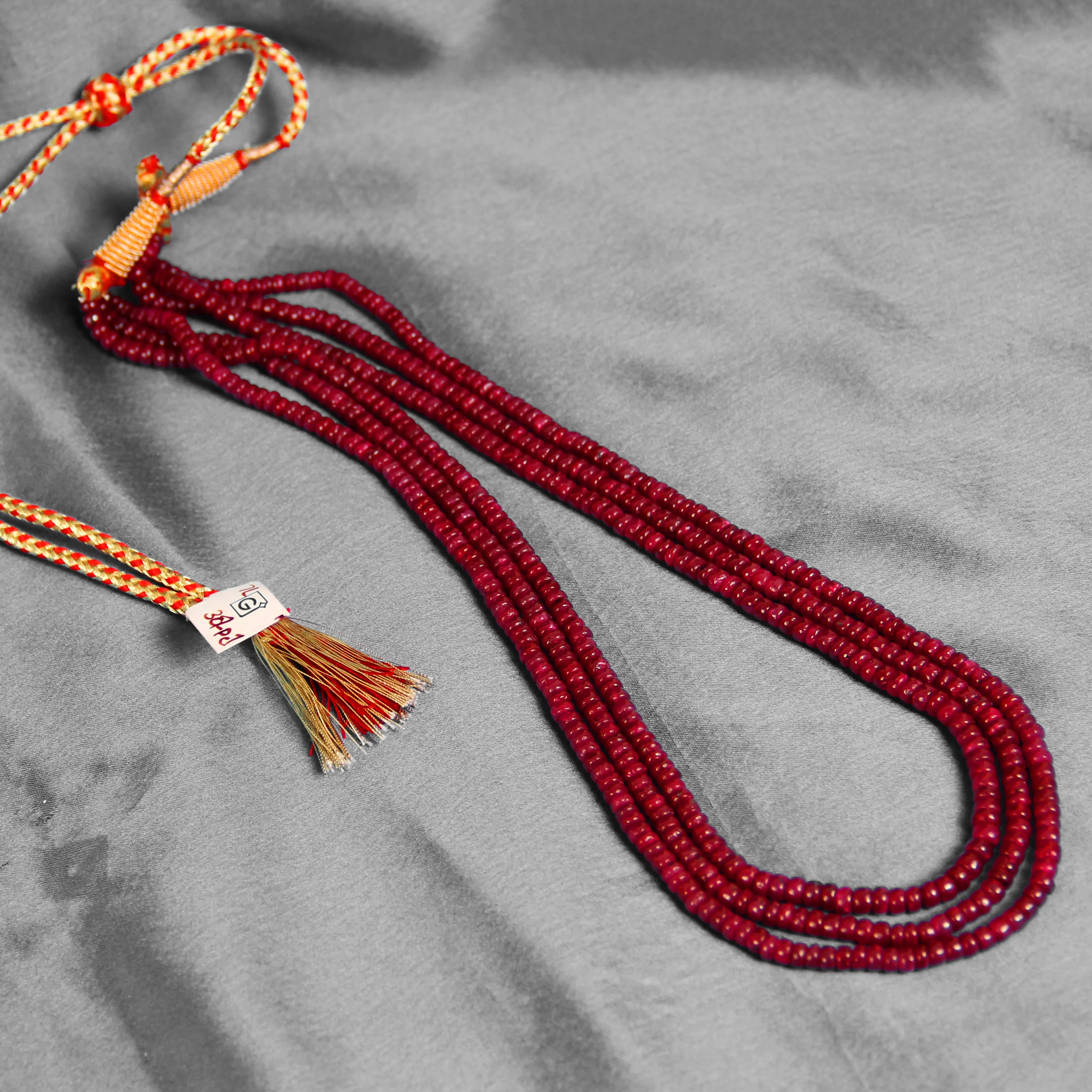 Red beaded multi-strand necklace with colorful thread